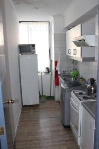a small kitchen with a stove and a refrigerator at Apartamento en Reñaca con Vista al Mar in Viña del Mar