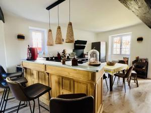 a kitchen with a counter with chairs and a table at Grande maison basque 14 pers, piscine, salle de jeux, internet, borne recharge - FR-1-495-132 in Hasparren