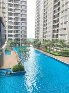 a large blue pool in a city with tall buildings at AYMAR Homestay, Youth City. in Nilai
