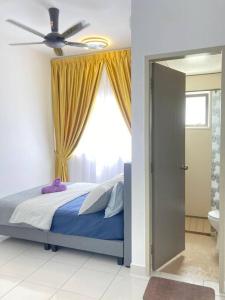 a bedroom with a bed with a ceiling fan and a window at AYMAR Homestay, Youth City. in Nilai