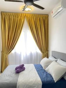 a purple teddy bear sitting on a bed in a bedroom at AYMAR Homestay, Youth City. in Nilai