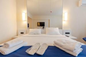 a large white bed with two pairs of slippers on it at Stylish Studio in New Batumi in Batumi