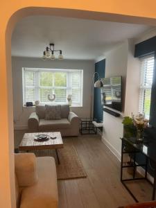 ein Wohnzimmer mit einem Sofa und einem Tisch in der Unterkunft Spacious Stylish House Close to M4 Private Parking in Magor