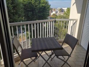 a table and two chairs on a balcony at Le Lido private apartment seaside, parking, swimming pool in Cagnes-sur-Mer