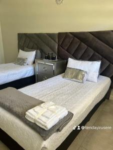 una camera con due letti e asciugamani di Feels Like Home Condo Victoria Falls a Victoria Falls