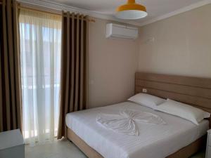- une chambre avec un lit blanc et une fenêtre dans l'établissement Armando Apartments, à Golem