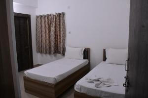 a bedroom with two beds and a window at Rivasa homes in Deoghar