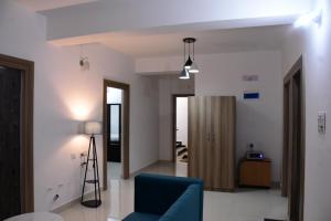 a living room with a blue couch and a doorway at Rivasa homes in Deoghar