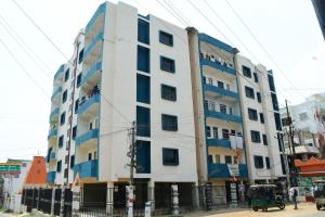 un edificio blanco con ventanas azules en una calle en Rivasa homes en Deoghar