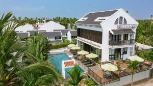 una vista aérea de una casa con piscina y sombrillas en Nghé Garden Resort Hội An by Label6 en Hoi An