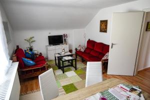 Sala de estar con 2 sofás rojos y TV en Stadtblick vom Herrengut, en Baden-Baden