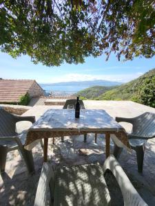 a picnic table with a bottle of wine on it at Authentic Mediterranean House with Postcard Sea View in Tivat
