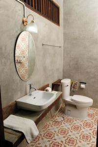 een badkamer met een wastafel, een toilet en een spiegel bij Phu-Anna Eco House in Hot