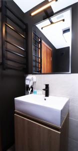 een badkamer met een witte wastafel en een spiegel bij 2BR Apartment in Marshall Gudauri Project in Goedaoeri