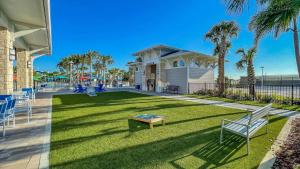 une maison dotée d'une pelouse avec un banc et des palmiers dans l'établissement Enchanted Villa, à Orlando