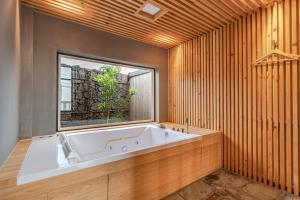 a large bath tub in a room with a window at Le Village Aewol G in Jeju