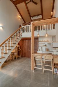 eine Küche mit einer Treppe, einem Tisch und Stühlen in der Unterkunft Le Village Aewol G in Jeju-do