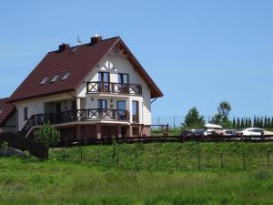 a house on a hill with cars parked at Dereniowe Wzgórze in Sejny