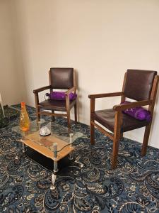 2 Stühle und ein Tisch mit einer Vase auf einem Teppich in der Unterkunft Enchanting Kashmir homestay in Srinagar