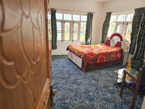 Schlafzimmer mit einem Bett und einem Fenster in der Unterkunft Enchanting Kashmir homestay in Srinagar