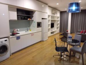 a kitchen and a living room with a table and a laundry at Platinum suites klcc by Fifty One in Kuala Lumpur