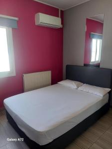 een slaapkamer met een wit bed en een rode muur bij Cottage Heights in Nicosia