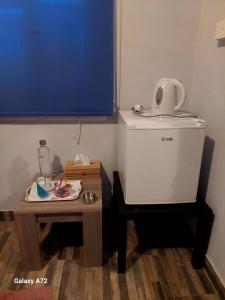 een kamer met een kleine tafel en een kleine koelkast bij Cottage Heights in Nicosia