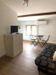 Saint-Didier的住宿－Logement neuf, tout confort, au coeur du village，卧室配有一张床和一张桌子及椅子