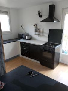 a kitchen with a stove and a counter top at Maison avec jardin in Caen