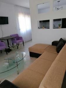 a living room with two brown couches and a piano at Nikitihouse Apartments 2 in Nikiti