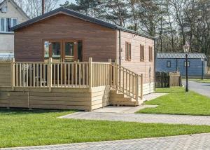 a small house with a wooden porch and a gate at Arran Hills in Kilwinning