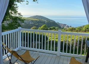 a balcony with two chairs and a view of the ocean at Lynmouth Holiday Retreat in Lynton