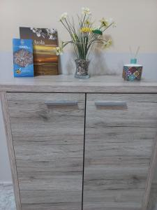 una cassettiera di legno con sopra dei fiori in un vaso di Largo Baluardo 13 ad Avola