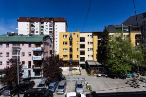 ein Parkplatz mit Autos vor den Gebäuden in der Unterkunft Moonlight Studio in Pristina