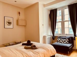een slaapkamer met een bed, een stoel en een raam bij ROBERT HOUSE in Londen