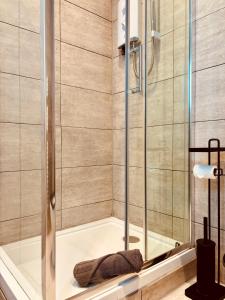 a shower with a glass door in a bathroom at ROBERT HOUSE in London