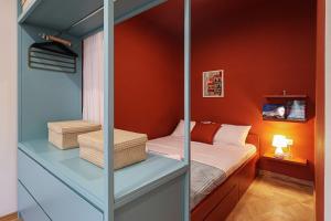 a small bedroom with a bed and orange walls at Modern 1BR apt w balcony in old Tbilisi-By Wehost in Tbilisi City