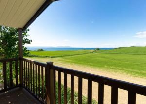 a balcony with a view of a green field at Heads Of Ayr Holiday Park in Ayr