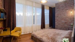 um quarto com uma grande janela com uma cama e uma cadeira em Comfy 3 Apartment house for 9 people em Tbilisi