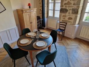 a dining room with a wooden table and chairs at Maison Ambre in Figeac