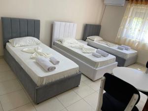a room with three beds with towels on them at Hotel bar restaurant Gjoçaj in Kolgecaj