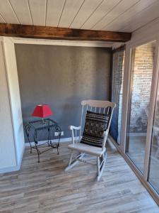 una silla en una habitación con una mesa y una lámpara en Maison Ambre, en Figeac