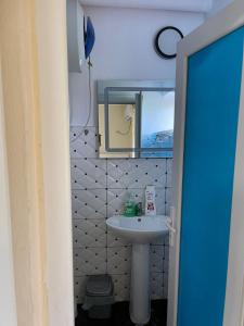 małą łazienkę z umywalką i lustrem. w obiekcie Hotel bar restaurant Gjoçaj w mieście Kolgecaj