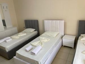 two beds in a room with towels on them at Hotel bar restaurant Gjoçaj in Kolgecaj
