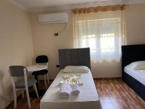 a room with a bed and a table with slippers at Hotel bar restaurant Gjoçaj in Kolgecaj