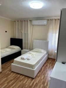 sypialnia z 2 łóżkami i pokój z: w obiekcie Hotel bar restaurant Gjoçaj w mieście Kolgecaj