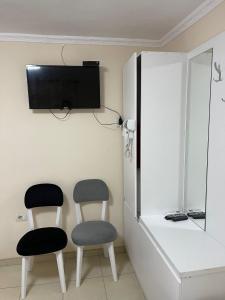 a room with two chairs and a tv on the wall at Hotel bar restaurant Gjoçaj in Kolgecaj