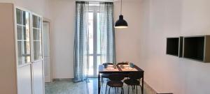 a room with a table with chairs and a window at La casa di Alessandro in Monopoli