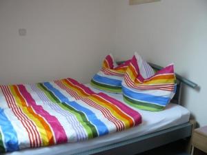 een bed met kleurrijke dekens en kussens erop bij Ferienwohnung für 2 Personen ca 31 qm in Altenau, Harz Oberharz in Altenau