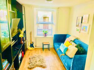 a living room with a blue couch and a window at 4 Market Street in Bantry